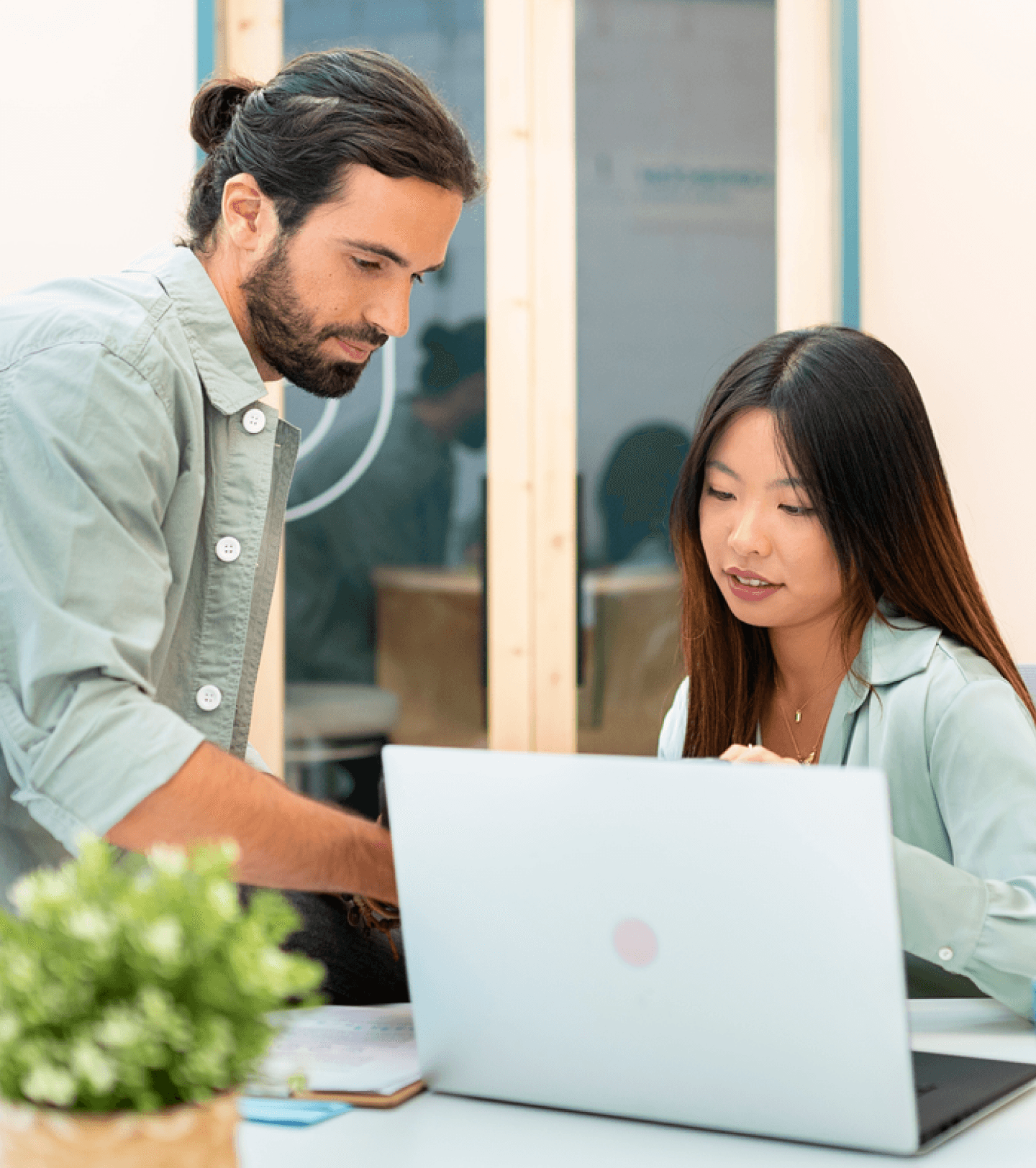 Man and woman collaborating while looking at a laptop screen