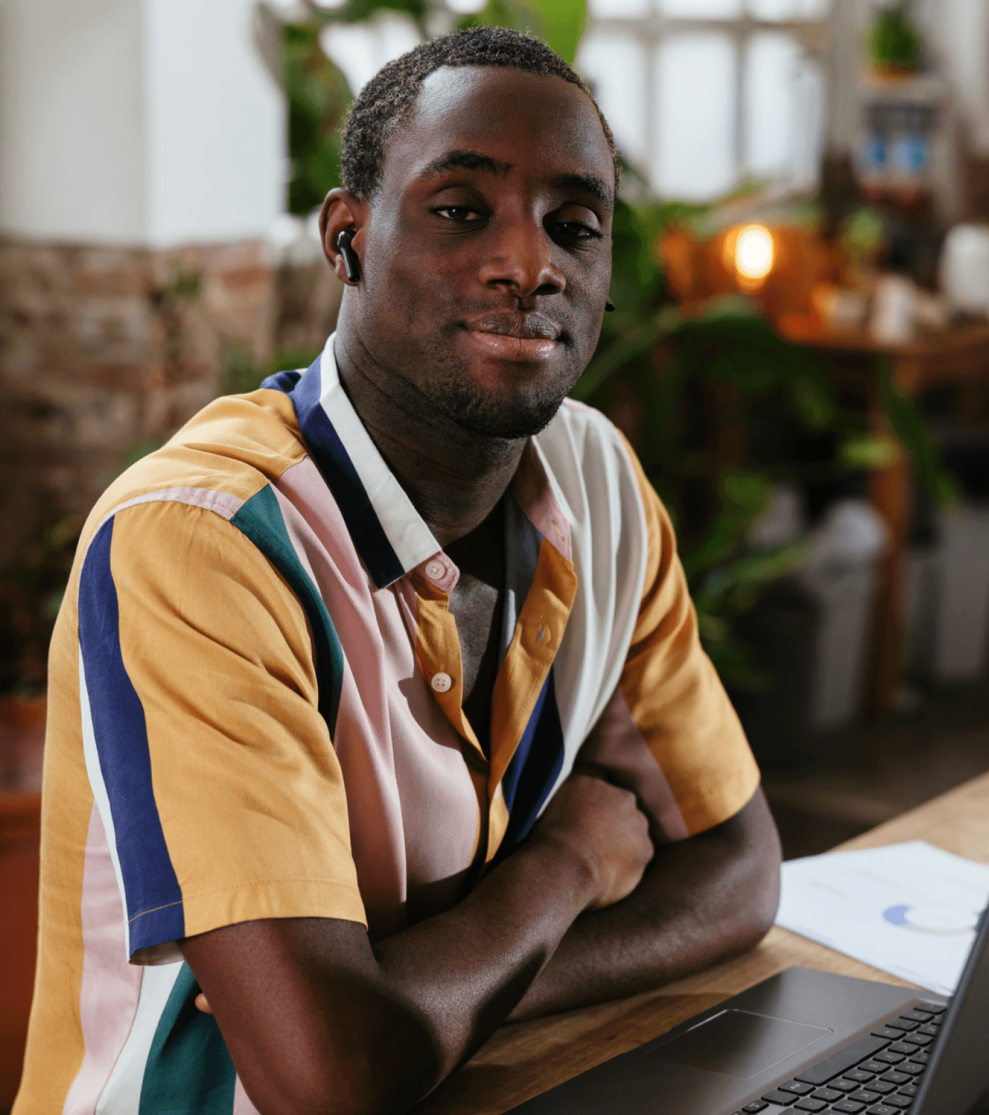 Man sitting at desk smiling sitting behind a laptop