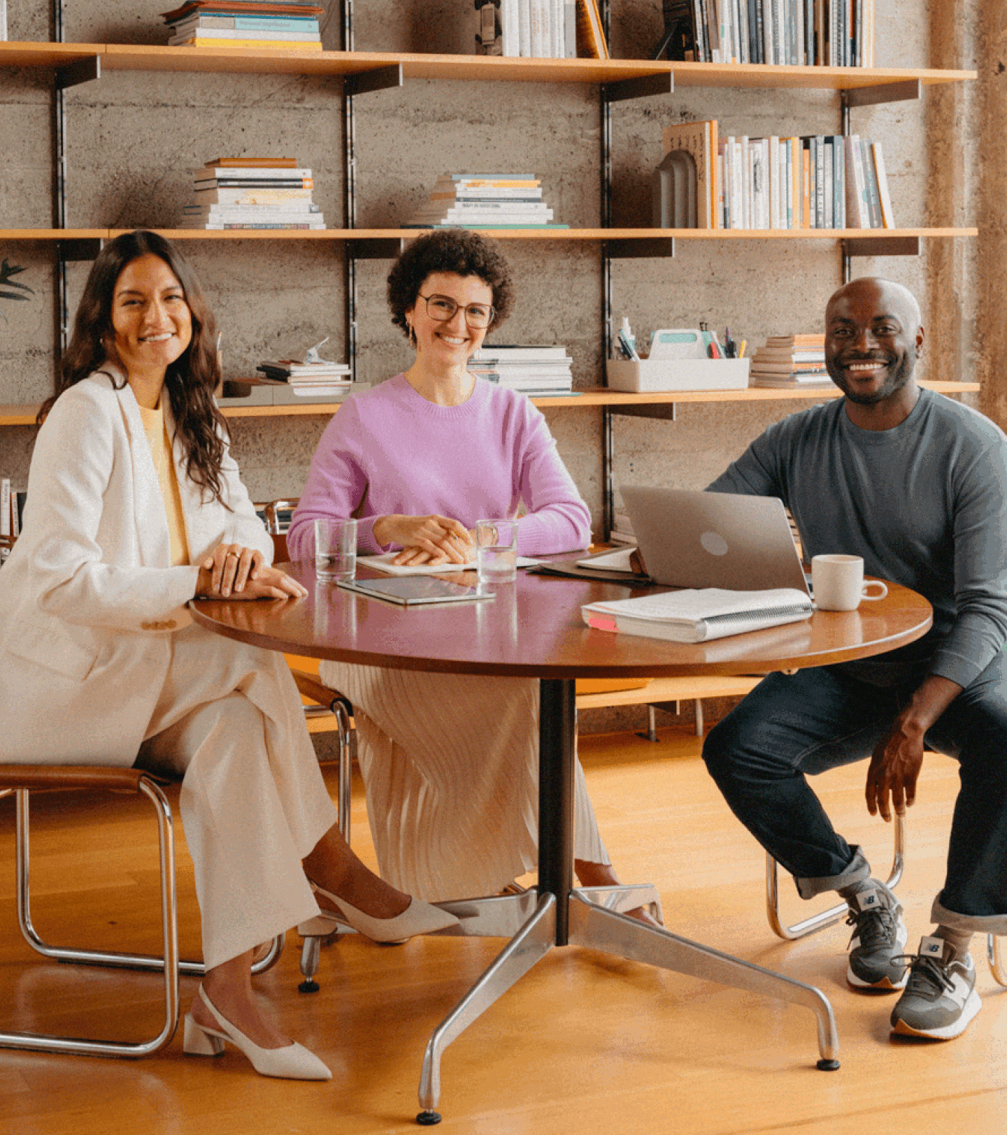Photo of female and male coworkers around a circle table in an office module