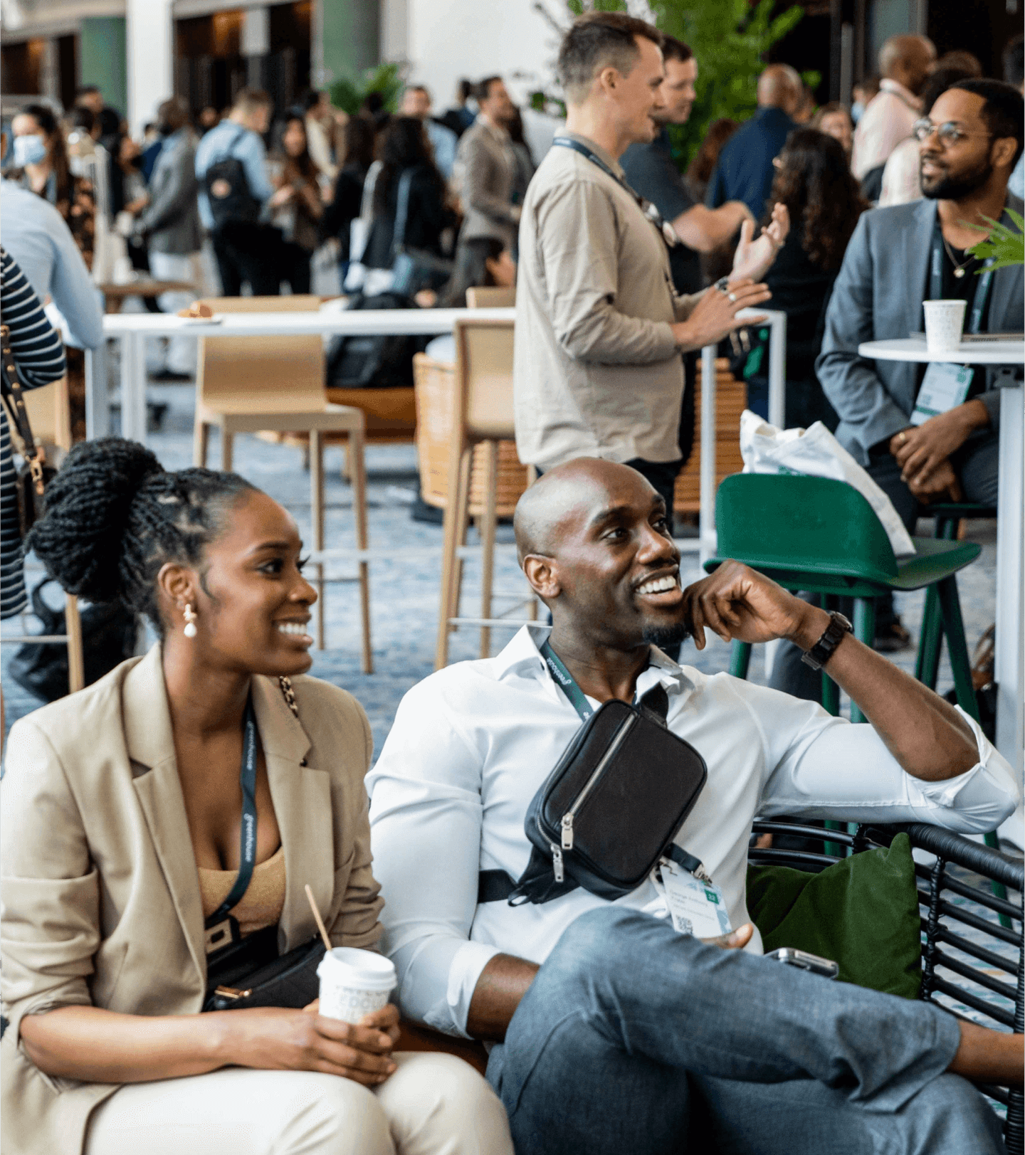 Two people sitting and smiling at an event space desktop